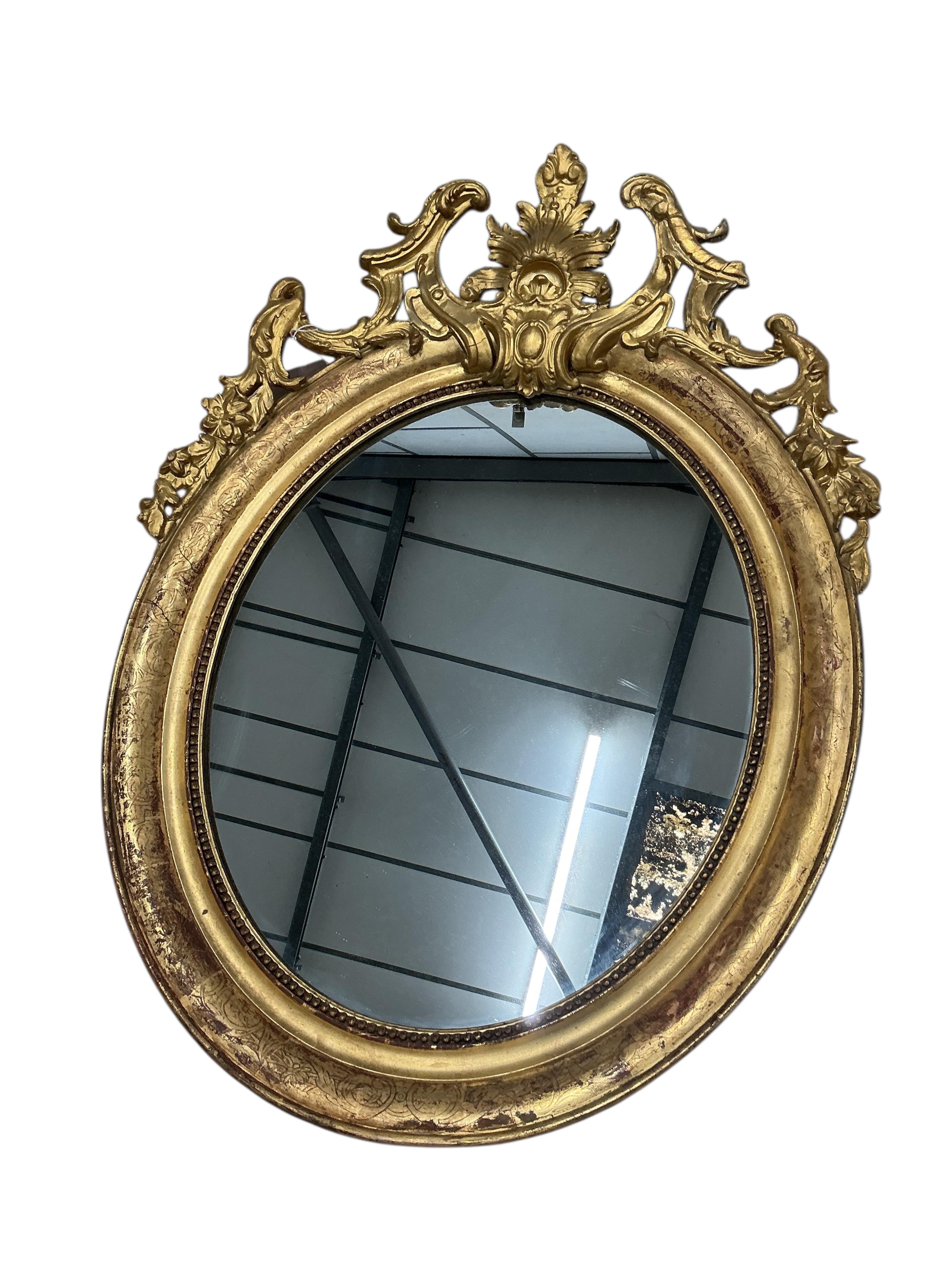 A pair of 19th century French giltwood and composition oval wall mirrors, width 68cm, height 91cm